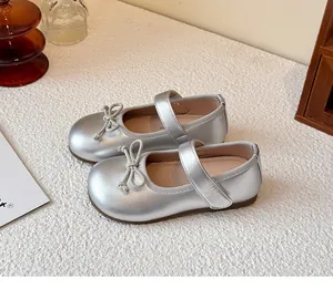 Detail view of silver girls' Mary Jane shoes featuring a cute bow and Velcro strap.