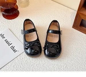 Close-up of girls' black patent leather Mary Jane shoes with cute bow detail.