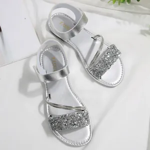Close-up view of silver glitter flat sandals with comfortable hook and loop strap design