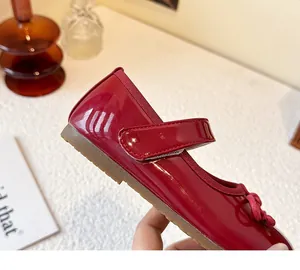 Close-up detail of girls' red patent leather Mary Jane shoes featuring soft rubber sole