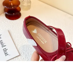 Close-up of girl's burgundy patent leather shoe insole with heart logo.