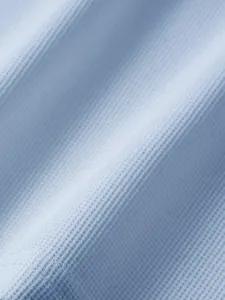 Vue macro d'un tissu en maille gaufrée bleu clair montrant la texture pour polo homme