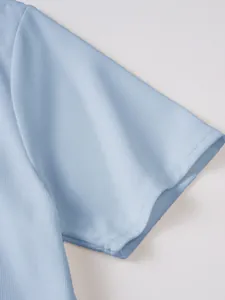 Gros plan de la texture nid d'abeille bleu clair sur la manche d'un polo pour homme.
