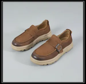 Close-up of vintage brown leather slip-on loafers for men with decorative buckle detail.