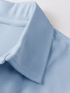 Vue macro détaillée de la texture gaufrée bleu clair sur le col d'un polo pour homme