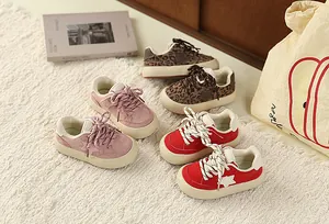 A collection of colorful kids retro star sneakers displayed on a soft textured rug