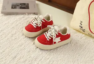 Side view of red children's retro sneakers with white star and thick cream sole