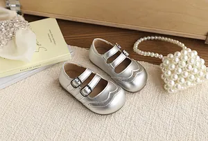Detailed view of silver British style Mary Jane shoes for girls on a textured mat