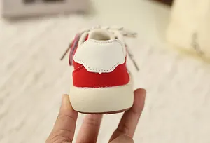 Detailed rear view showing the heel of red and beige children's retro sneakers with thick soles