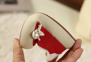 Close-up view showing the highly flexible sole of kids' red and cream retro sneakers