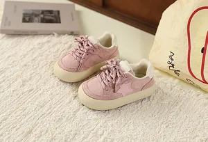 Close-up of pink toddler sneakers with star detail and a thick cream-colored sole.