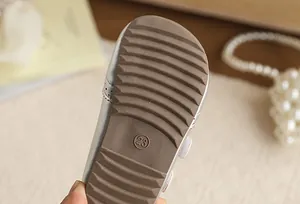 Macro detail showing the anti-slip brown rubber sole of children's walking shoes