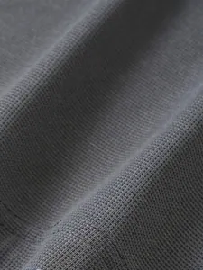 Gros plan détaillé montrant la texture du tissu gaufré gris de qualité sur un polo homme