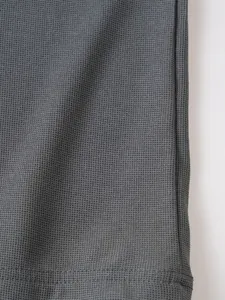 Détail en gros plan de la texture du tissu nid d'abeille gris et de l'ourlet pour polo