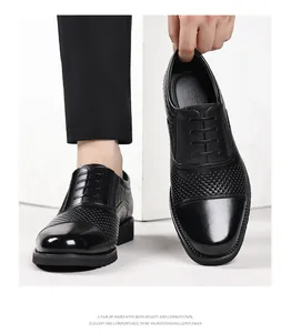 Gros plan sur des chaussures habillées en cuir noir pour hommes avec détails perforés.