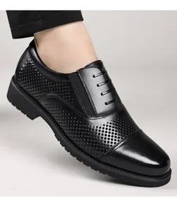 Gros plan détaillé de chaussures habillées en cuir perforé noir à lacets classiques.