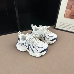 Gros plan de baskets respirantes pour enfants en blanc et bleu marine avec semelles antidérapantes