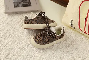 Detail of children's leopard print sneakers with star patches and thick cream soles.