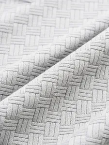 Detailed close-up of the grey basket-weave jacquard texture on men's polo shirt.
