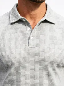 Close-up of the jacquard texture and white buttons on a gray men's polo shirt