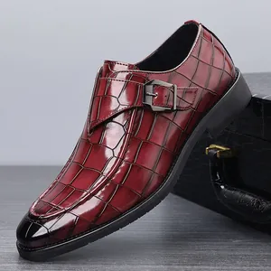 Detailopname van bordeauxrode heren monk strap loafer met krokodillenleer textuur