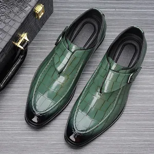 Detailopname van groene herenloafers met krokodillentextuur en elegante metalen gesp.