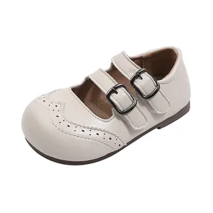 Cream British style girl's Mary Jane leather shoes with double buckle straps and brogue toe.