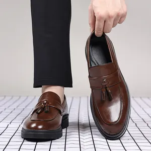 Gros plan détaillé de mocassins en cuir marron avec glands et semelle noire épaisse