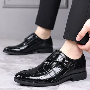 Detailopname van zwarte leren herenloafers met krokodillenpatroon en een zijgesp