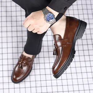 Gros plan de mocassins à glands en cuir marron pour hommes au design élégant à enfiler.