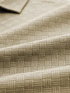 Close-up of the beige jacquard basket-weave texture on a premium men's polo shirt
