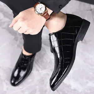 Detailopname van zwarte glanzende loafers met krokodillenpatroon voor heren in gebruik