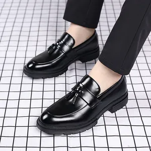 Gros plan détaillé de mocassins à glands noirs brillants pour hommes sur un sol quadrillé