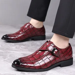 Close-up detail van bordeauxrode monk strap loafers met een krokodillenreliëf en gesp detail