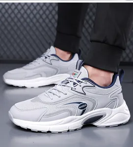 Detailed side view of men's grey and navy blue breathable athletic sneakers mesh upper