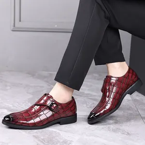 Detailweergave van elegante bordeauxrode herenschoenen met krokodillenpatroon en gesp