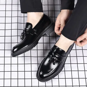 Détail montrant le design élégant des glands et la texture du cuir des mocassins noirs.