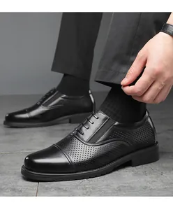 Close-up of men's black perforated leather business dress shoes with cap toe design