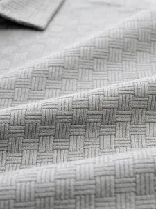 Detailed macro shot showcasing the grey jacquard woven fabric texture of a men's polo shirt