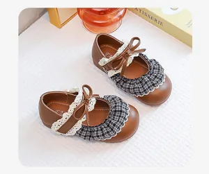 Detailed view of vintage brown Mary Jane shoes for girls with lace and plaid ruffles