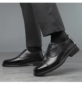 Side view detail of black breathable leather dress shoes with perforated cap-toe design