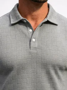 Macro detail of a grey men's jacquard polo shirt showing fabric texture and buttons.