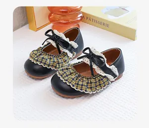 Detail of retro girls' Mary Jane shoes with plaid ruffles and delicate lace trim.