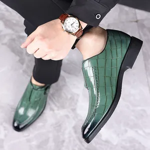 Gedetailleerd overzicht van groene heren loafers van leer met krokodillenmotief
