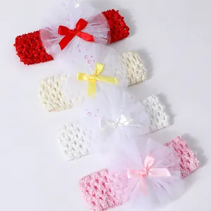 Detailed view of four colorful baby crochet headbands with large white tulle lace flowers