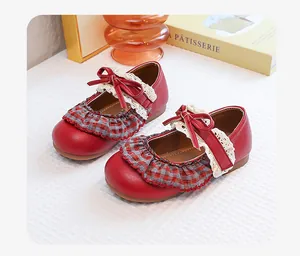 Close-up of red girls' vintage Mary Jane shoes with lace and plaid ruffles