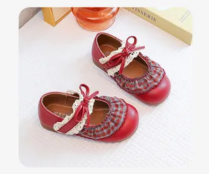 Close-up detail of girls red retro Mary Jane shoes with plaid ruffle and bow