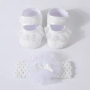 Detailed view of white lace baby shoes and matching bow headband set for newborn infants