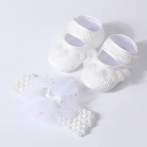 Detailed view of white lace baby walker shoes and matching bow headband set for infants