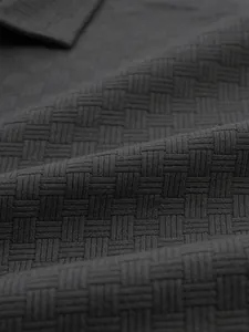 Close-up detail of the dark gray jacquard woven fabric texture on a men's polo shirt